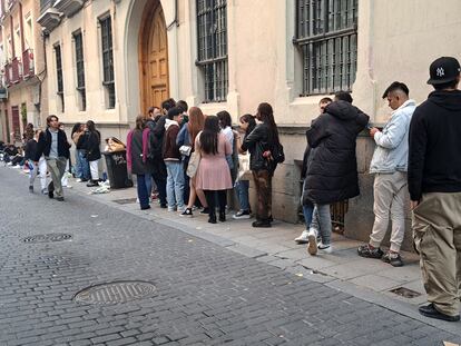 Varios jóvenes hacen cola para entrar a una tienda efímera en el centro de Madrid.