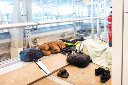 Two migrants sleep in a hallway in the transit area of Barajas’ T4.