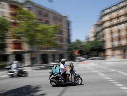 Un repartidor de entrega a domicilio conduce por Barcelona, en julio de 2019.
