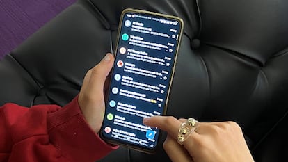 Una joven consulta su teléfono móvil.