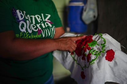 Delmy Cortéz holds the embroidery made by her daughter Beatriz before her death.