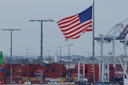 Una bandera estadounidense ondea junto a contenedores llegados de China en el puerto de Los Ángeles, el pasado 1 de mayo.