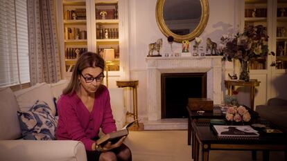 Carmen Posadas leyendo en el salón de su casa de Madrid.