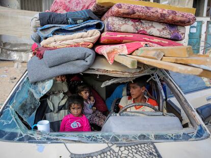 Palestinos desplazados se sientan en un automóvil dañado mientras huyen de la parte oriental de Khan Younis tras una orden de evacuación israelí el 7 de octubre de 2024.